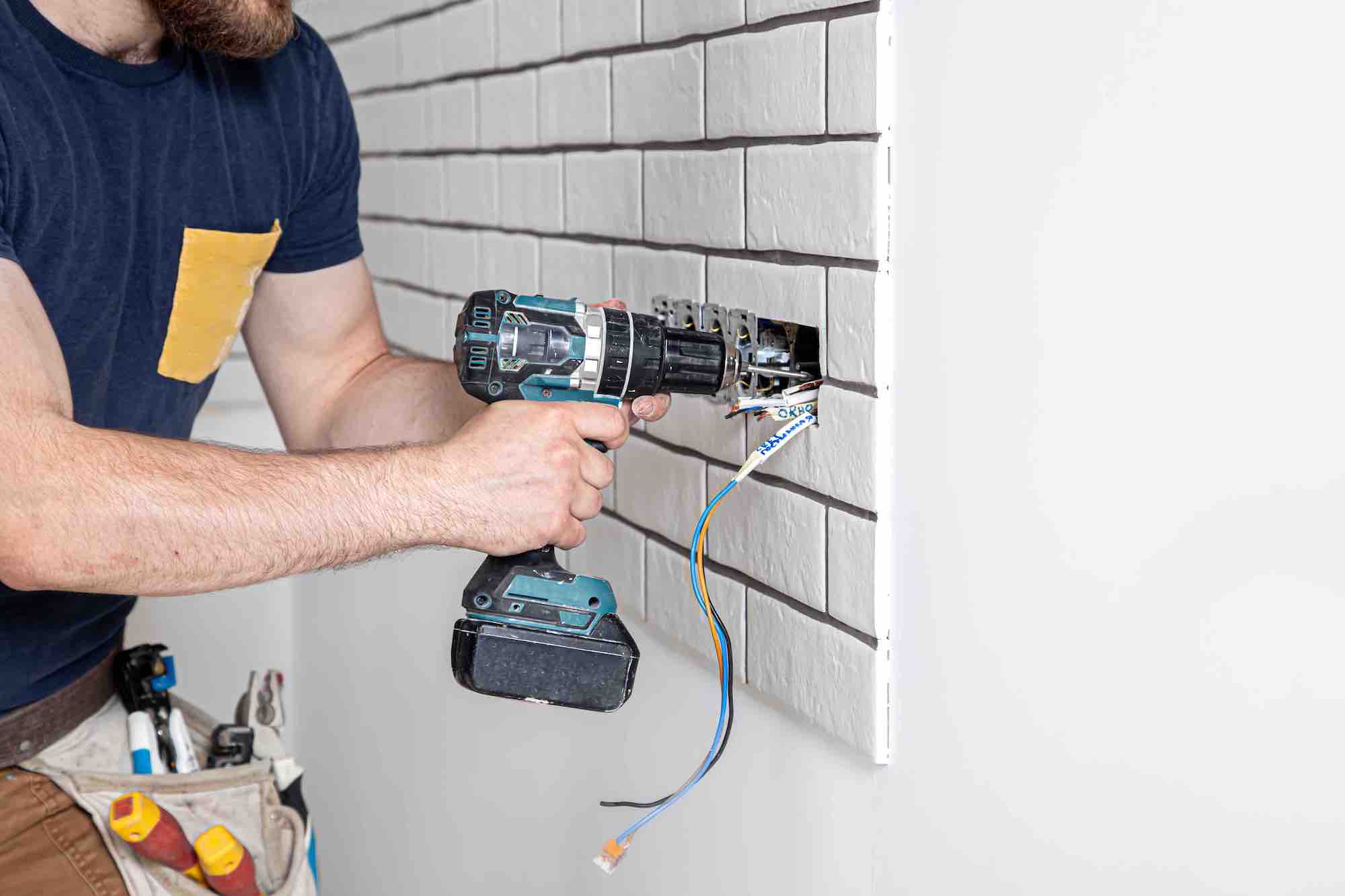 Worker installing a dobule socket into kitchen wall