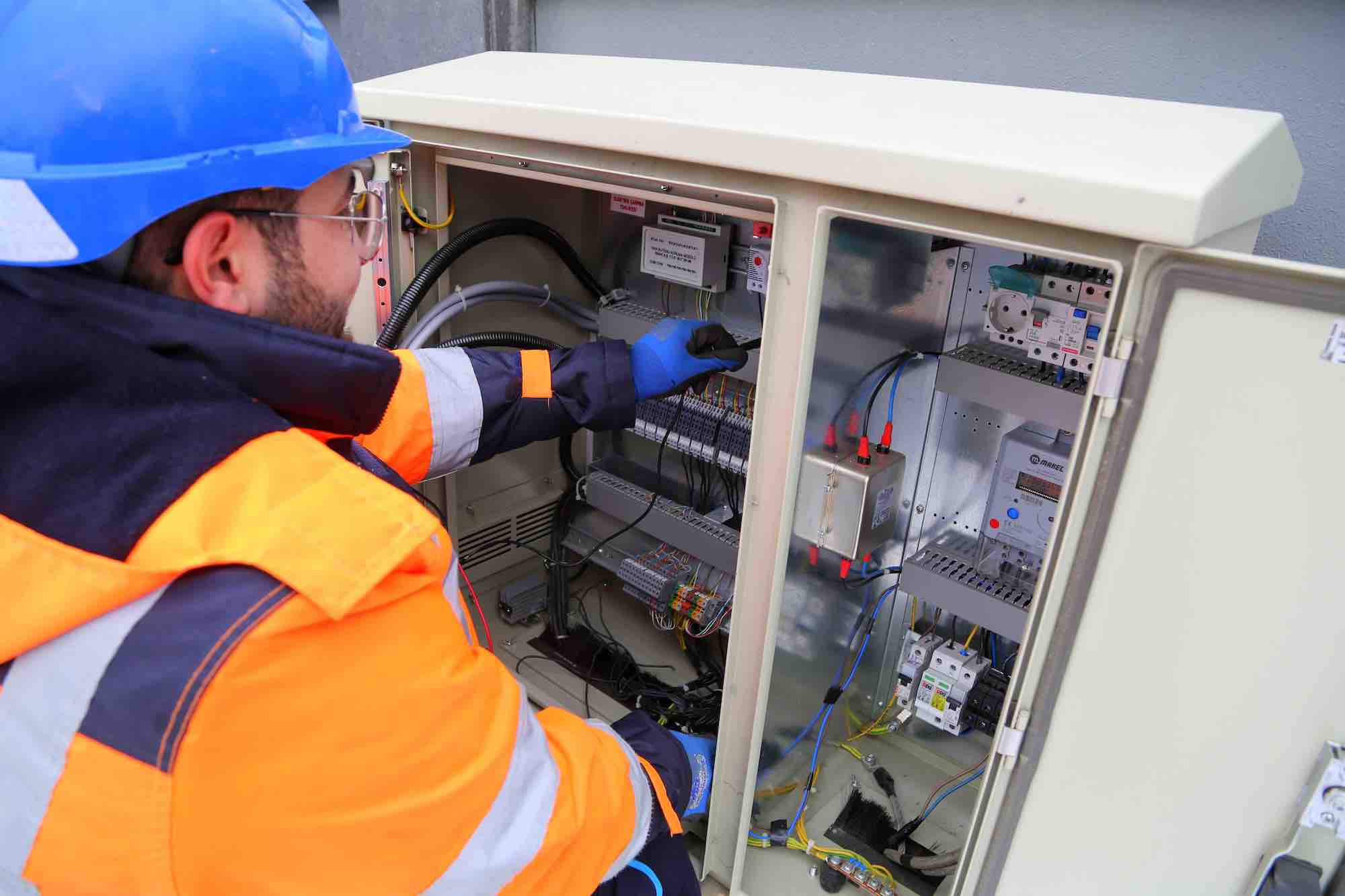 Engineer testing relays inside substation unit